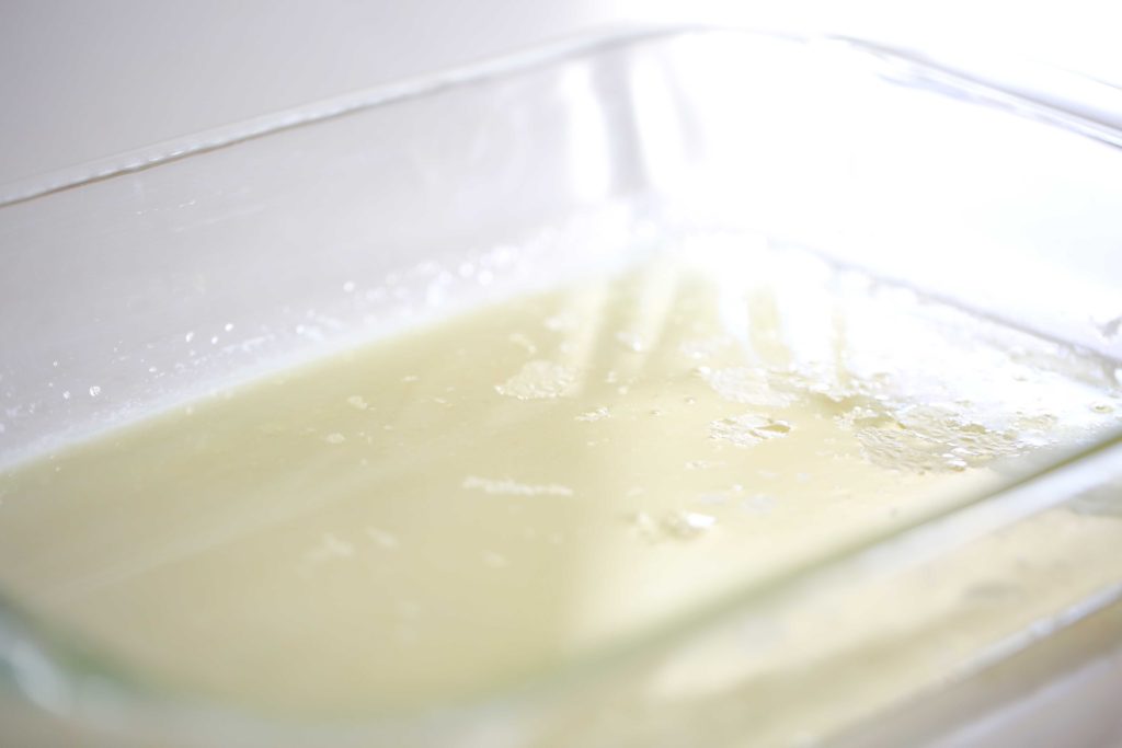 Swirl the melted butter about an inch up the sides of the pan to grease it. Then layer the remaining ingredients as follows: